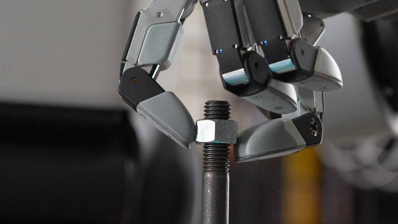 ナット付きのねじ軸をつまむ Boston Dynamics の新世代ハンド「GR3」。親指のほかに指は3本で、小指にあたる指がない（提供：Boston Dynamics）